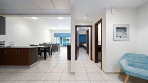 Eine moderne Hotelhalle mit Rezeption, Essbereich und blauem Sessel.