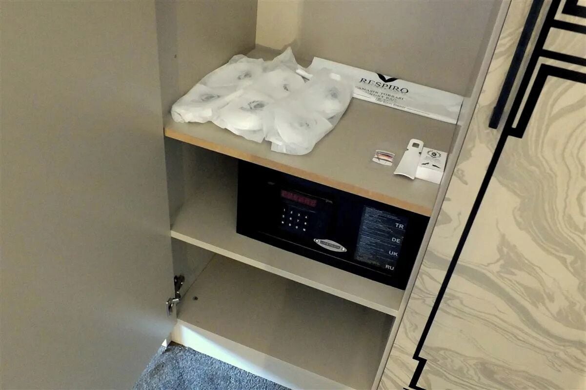 Une chambre d’hôtel équipée d’un mini-bar, d’un panneau de commande numérique et d’un distributeur de serviettes.