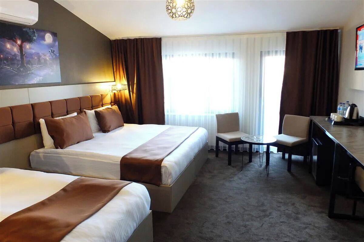 Une chambre d’hôtel avec deux lits, un bureau et une chaise.