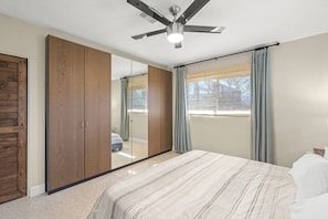 A bedroom with a bed, a ceiling fan, a wardrobe, and a window with curtains. - Sarasota 'Starburst' Home | Heated Pool | Dogs OK (Sarasota)