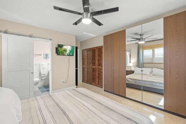 A bedroom with a bed, a ceiling fan, a television, and a wardrobe. - Sarasota 'Starburst' Home | Heated Pool | Dogs OK (Sarasota)
