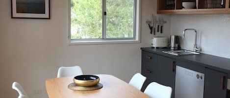 Une cuisine moderne avec une table à manger, des chaises, une fenêtre et un évier.