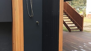 A wooden deck with a staircase leading to a dark-colored door with a keyhole. - Lago is the heart of North Bendalong (Bendalong)
