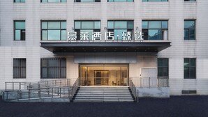 A modern building with a glass entrance and a staircase leading up to it. - Jinglai Hotel Shanghai Songjiang  (Shanghai)