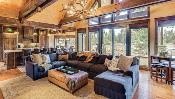 A spacious living area with a large sectional sofa, a fireplace, and a view of the outdoors.