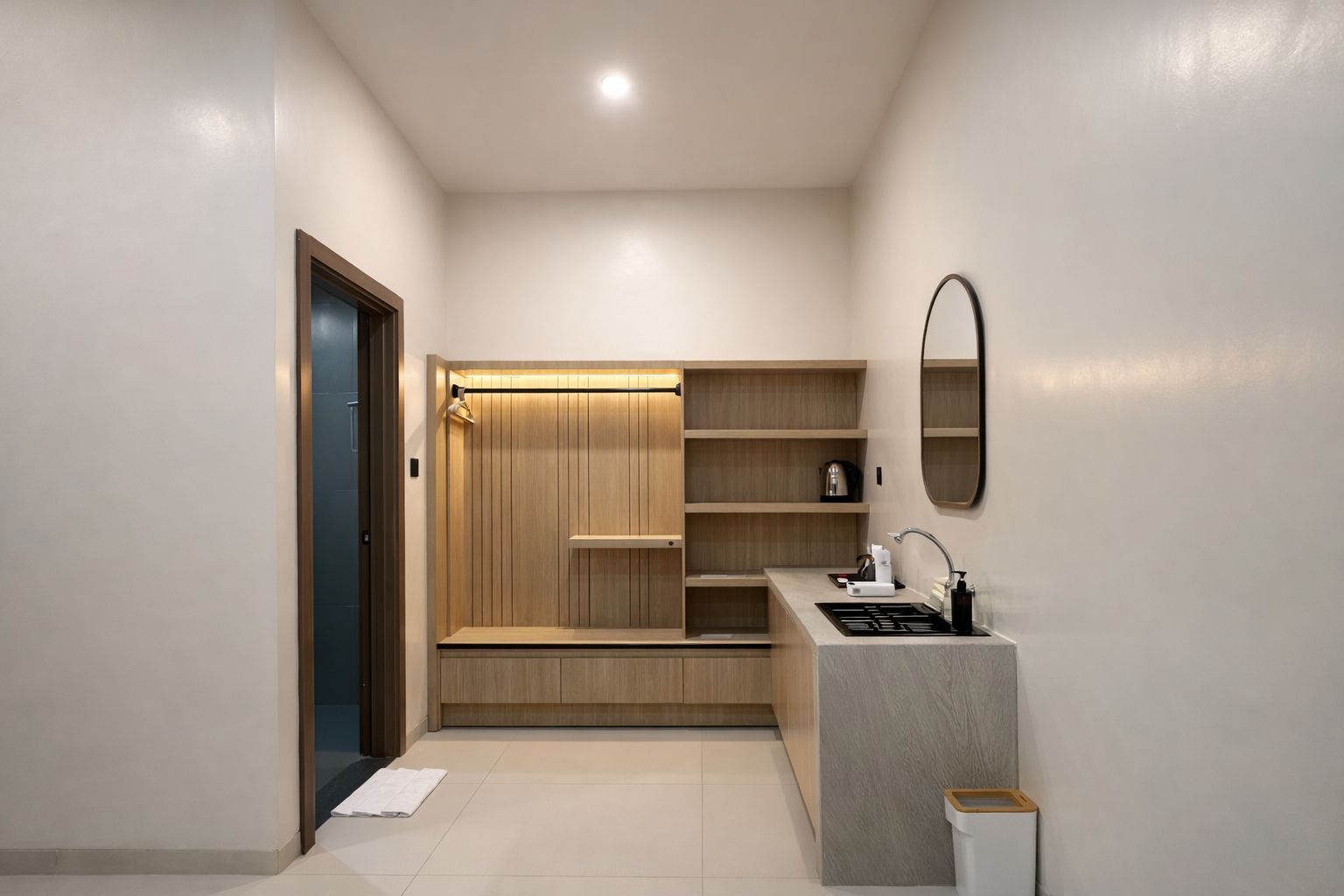 A compact kitchenette with a built-in oven, a sink, and a mirror above it.