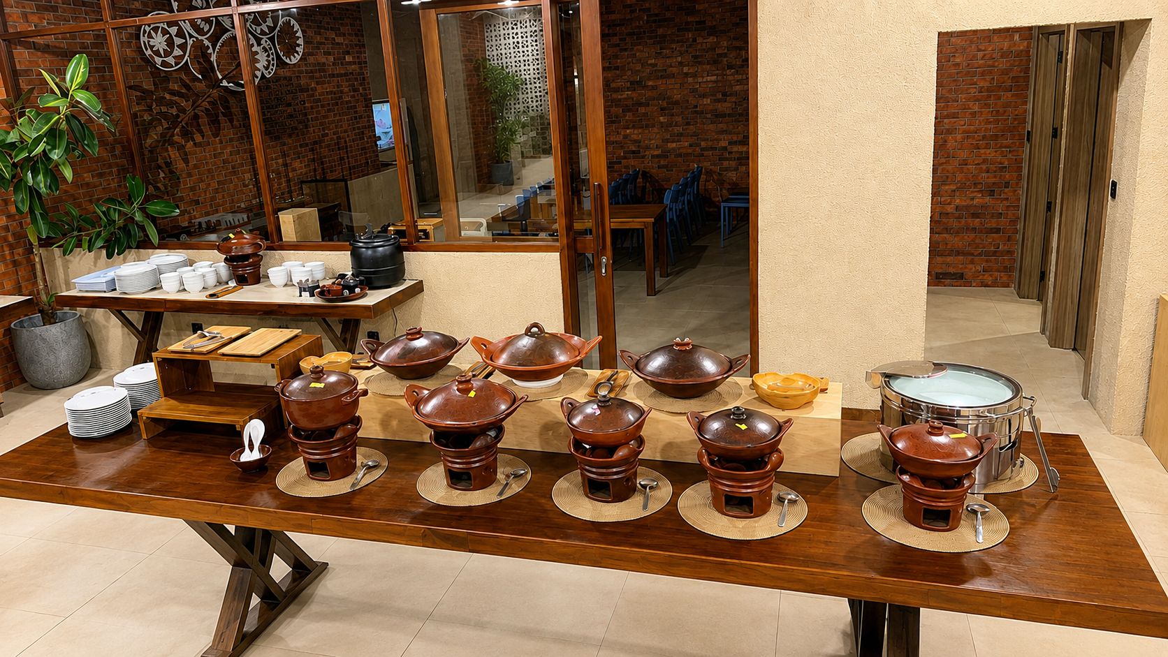 A dining area with a long wooden table set with traditional pottery and plates.