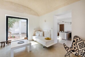 Een moderne, minimalistische slaapkamer met een bed, nachtkastje en uitzicht op het groen.
