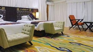 A hotel room with two beds, a large window, and a colorful carpet. - Tenzinling Luxury Villa Tent (Paro)