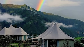 A mountain landscape with a rainbow and two white tents. - Tenzinling Luxury Villa Tent (Paro)