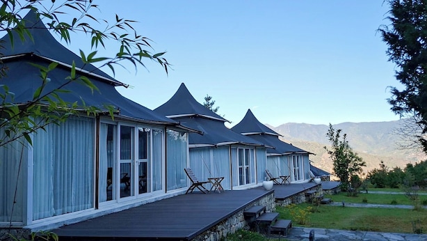 A row of modern, chalet-style buildings with large windows and a wooden deck. - Tenzinling Luxury Villa Tent (Paro)