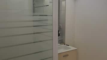 Chuveiro, toalhas de banho, sabonete, papel higiênico