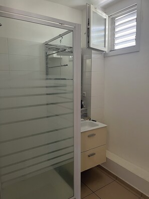 Chuveiro, toalhas de banho, sabonete, papel higiênico