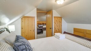 Un dormitorio con una cama grande, un armario de madera y vistas a una sala de estar con sofá y chimenea.