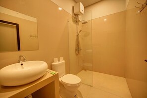 A bathroom with a sink, toilet, and glass-enclosed shower area. - The Joy Rooms Penida (Penida Island)