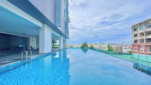 A modern hotel with a rooftop infinity pool, a covered outdoor seating area, and a view of the cityscape. - Melaka Ong Kim Wee Residence by Stayrene (Malacca City)