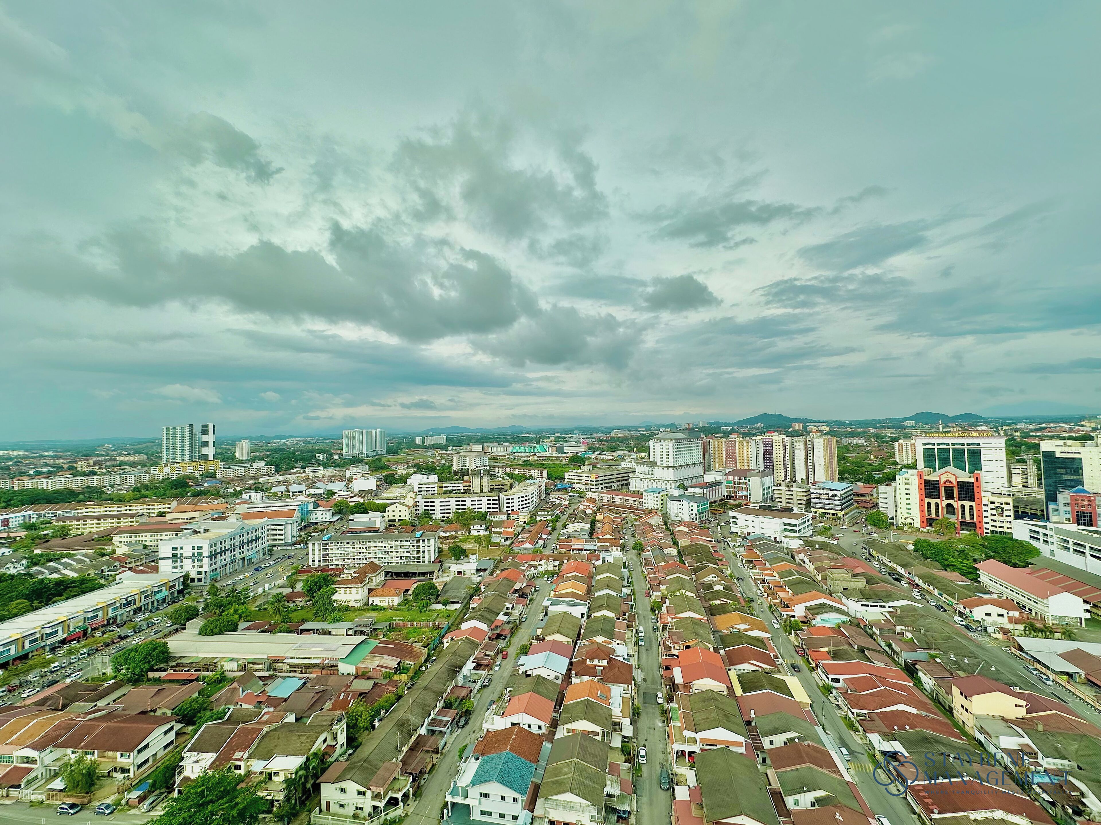 A residential area with a variety of buildings, including high-rise apartments and single-family homes, under a cloudy sky.
