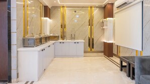 Un baño moderno con piso de mármol, un lavabo con espejo y una zona de ducha.