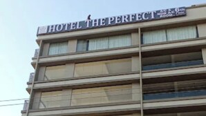Ein mehrgeschossiges Gebäude mit der Aufschrift 'HOTEL THE PERFECT', das als Hotel gekennzeichnet ist.