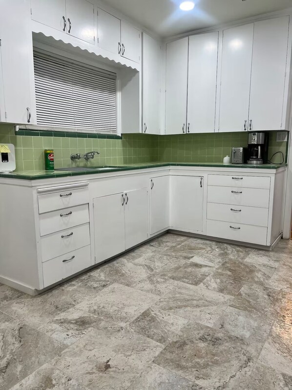 A kitchen with white cabinets, green tiles, a built-in oven, and a coffee maker. - Lovely 3-bedroom house with AC in vibrant Santa Ana 10 Minutes From Disneyland (Santa Ana)