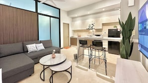 Un salon moderne avec un canapé, deux tables rondes et un ventilateur de plafond.