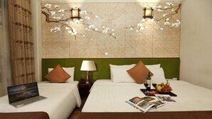 A hotel room with two beds, a laptop on one bed, a magazine, and a fruit basket on the other. - Hanoi Golden Lotus & Spa (Hanoi)