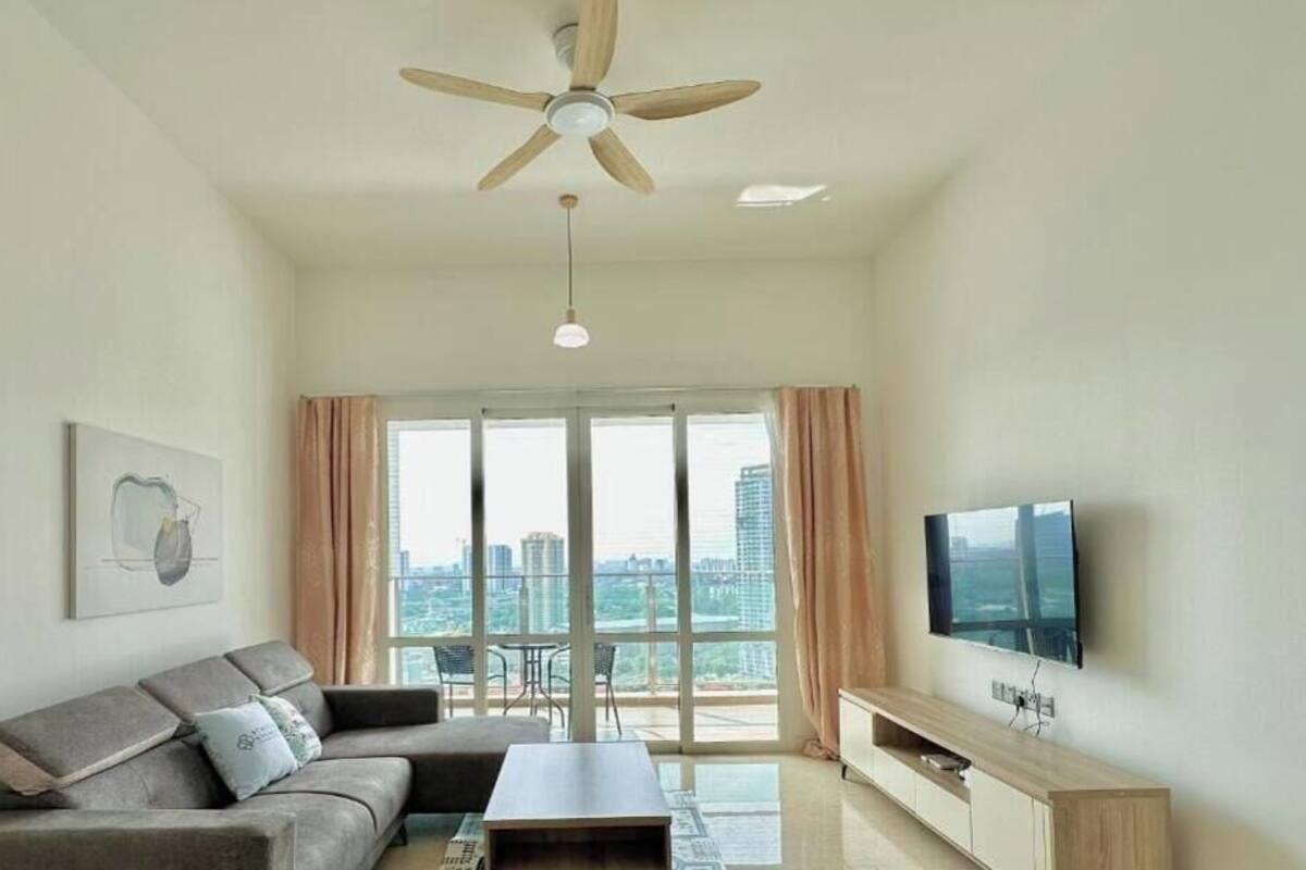 Un salon moderne avec un canapé, une table basse, un téléviseur et un ventilateur de plafond.