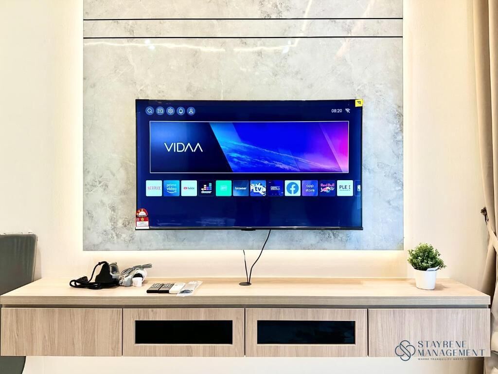 A flat-screen TV mounted on a wall with a modern design, displaying the VIDAA app interface.