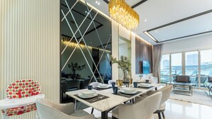 A modern dining area with a high table, chairs, and a baby high chair.