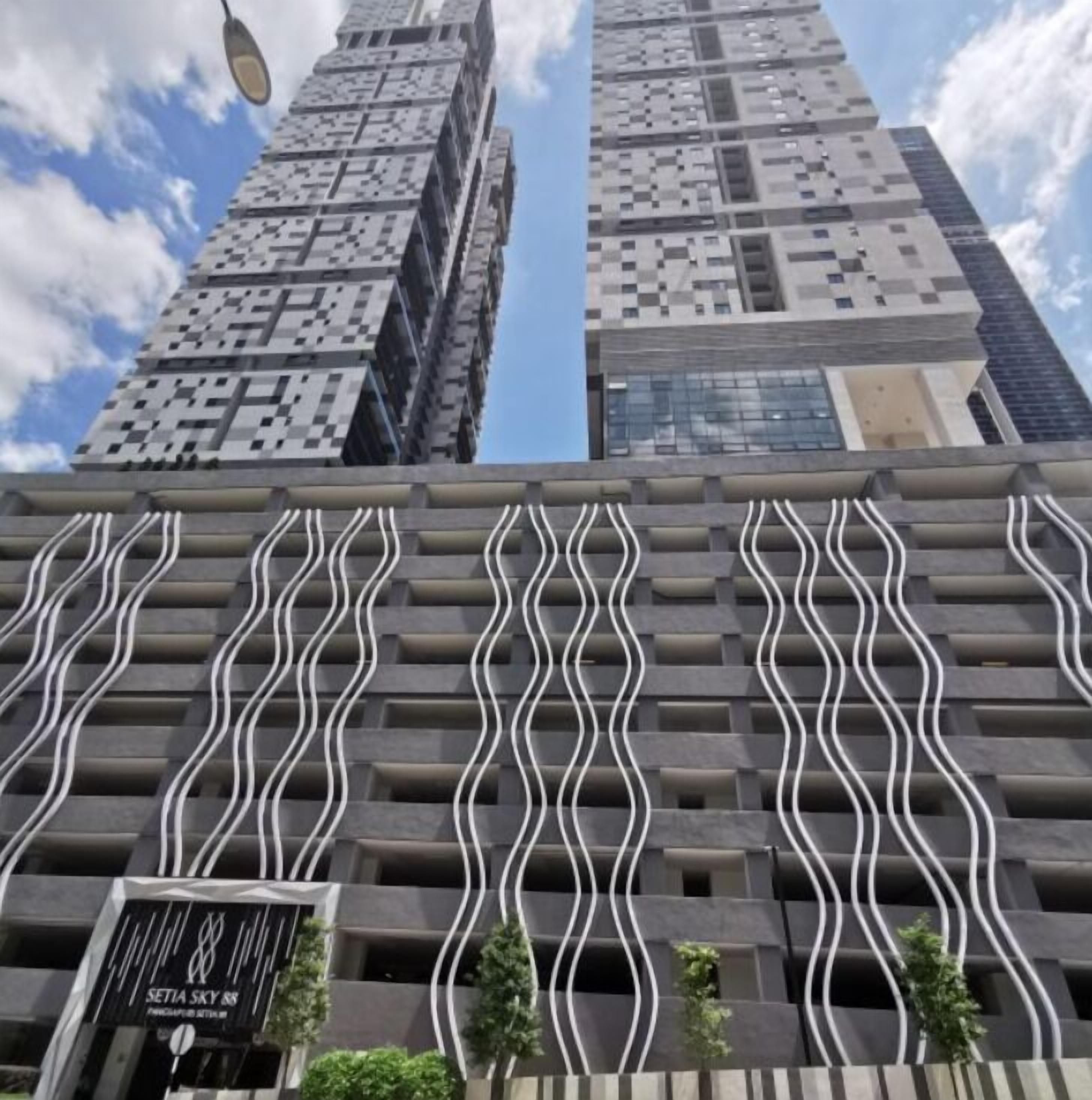 Ein modernes Gebäude mit einer markanten, wellenförmigen Fassade und einem Schild, auf dem 