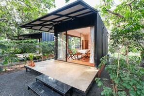 Un patio moderno al aire libre con zona de comedor, una mesita y un banco.