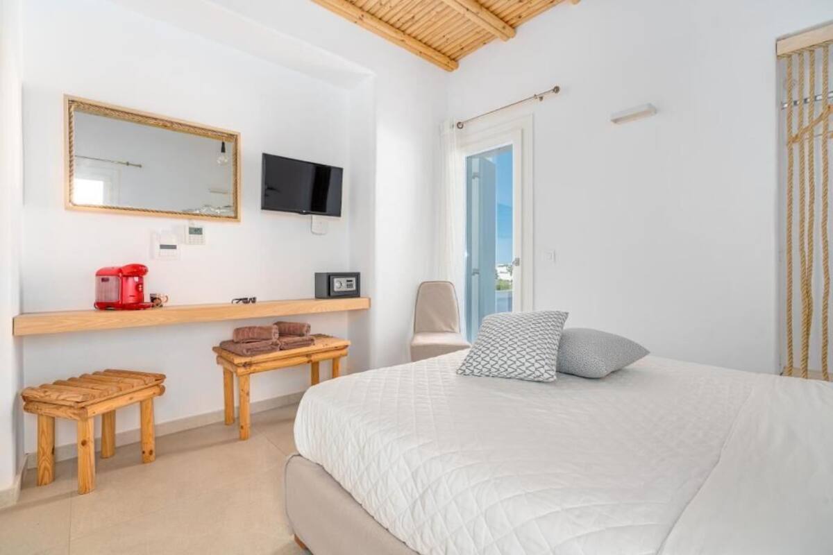 Une chambre avec un lit, une télévision, une machine à café et une petite table.