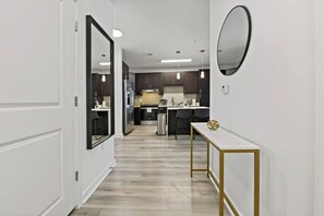 A modern kitchen with dark cabinets, stainless steel appliances, and a white countertop. - Midtown Gem Steps to Uptown & Queens University! (Charlotte)