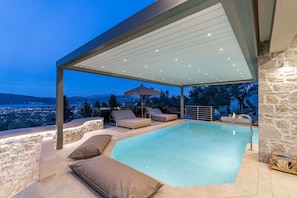 A rooftop pool with lounge chairs and a pergola, overlooking a cityscape. - Isle of View Villa - Lefkada (Lefkada)