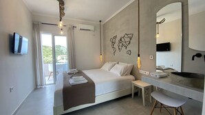 A modern hotel room with a large bed, a small desk, a vanity with a basin, and a television on the wall. - Ninfas del Mar (Lefkada)