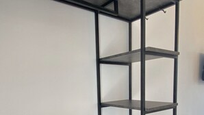 A metal shelving unit with multiple shelves and drawers, likely used for storage in a room. - Ninfas del Mar (Lefkada)