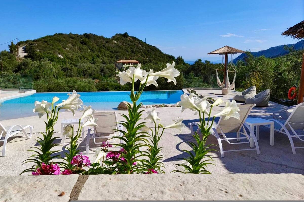 Ein Poolbereich mit Liegestühlen, einer Hängematte und Blumen.