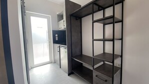 A kitchen with a built-in oven, a microwave, and a refrigerator. There is a door leading to a balcony. - Ninfas del Mar (Lefkada)
