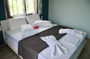A neatly made bed with white linens, a brown quilt, and a towel folded on the side. - Sea Breeze Apartment n 2 (Lefkada)