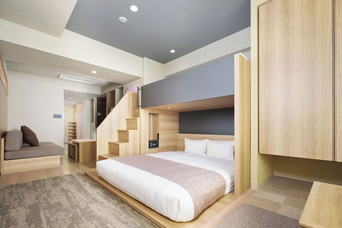 Un dormitorio moderno con cama, armario empotrado y una escalera.