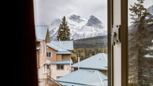 Un chalet de montagne avec vue sur les sommets enneigés.