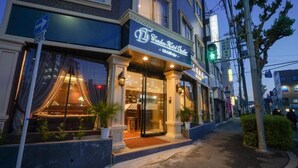 Un hôtel doté d’une entrée imposante, d’une enseigne bien visible et d’une façade bien éclairée.