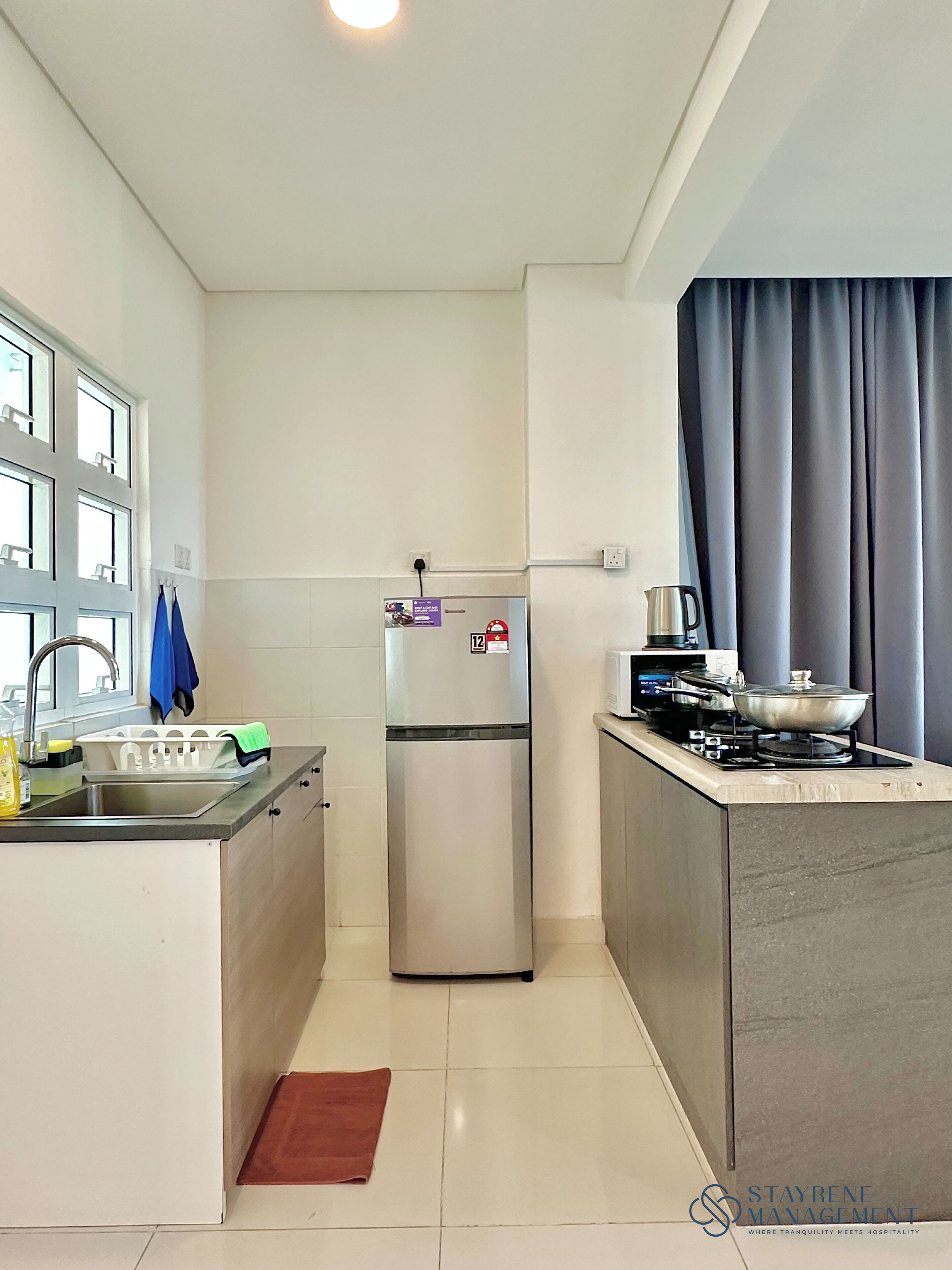 A compact kitchen with a refrigerator, sink, and stove.