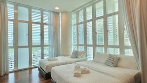 A hotel room with two beds, large windows, and a view of the city. - 1 Medini Residence Neo by Stayrene (Iskandar Puteri)