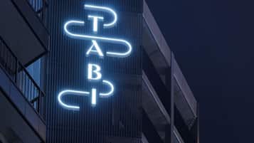 A building with a neon sign spelling 'TAB' in a stylized font.