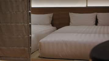 A hotel room with two beds, a wooden headboard, and a curtain.