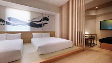 A hotel room with a bed, a desk, a TV, and a wall with abstract art.