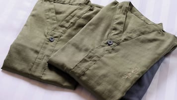 Two folded shirts with buttons and a small embroidered detail on one.