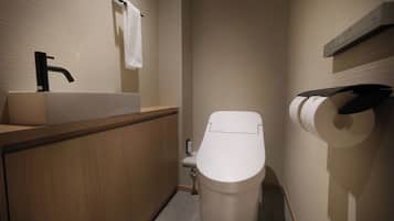 Een moderne badkamer met een wastafel, toilet en handdoekrek.