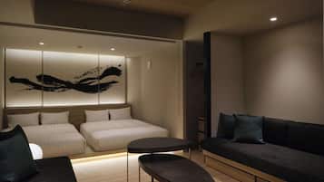 Une chambre d’hôtel moderne équipée d’un lit, d’un canapé, d’une petite table et d’une œuvre d’art accrochée au mur.